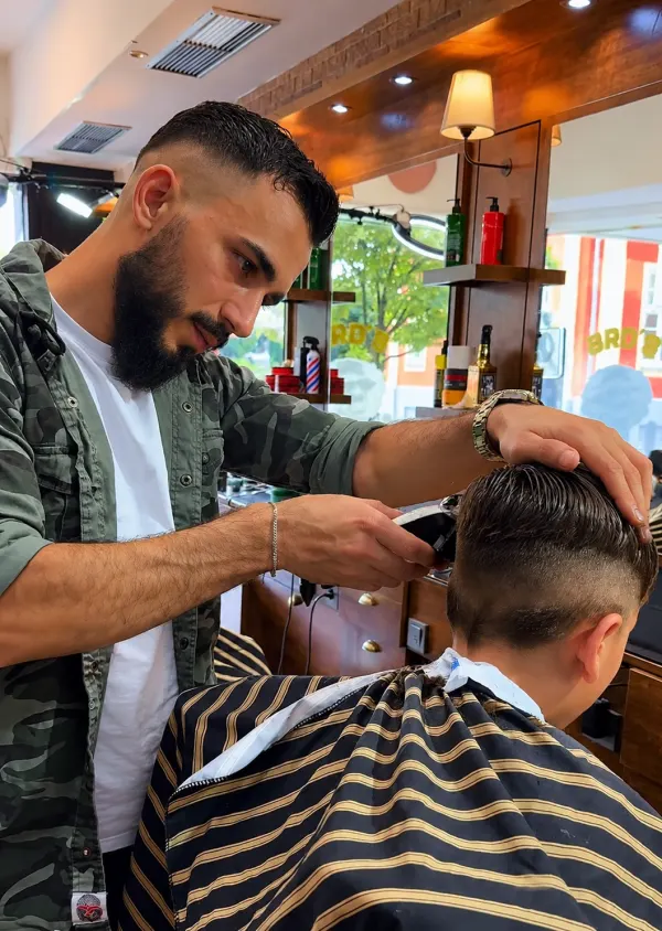 Humam Mounther, Inhaber von Bro’s Barbershop in Hamm, bei einem Fade-Haarschnitt mit der Haarschneidemaschine