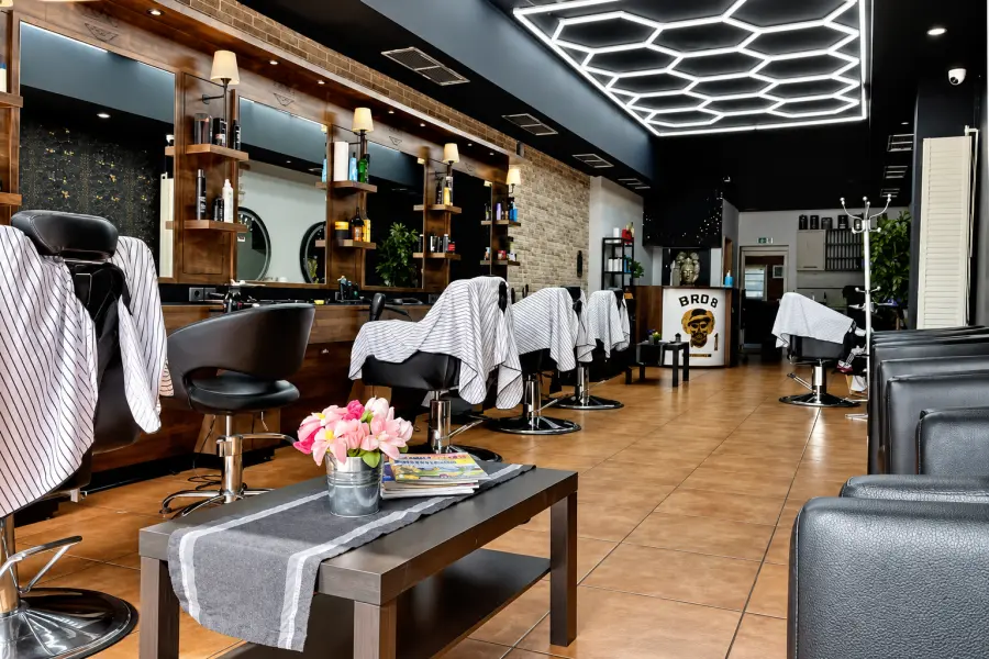 Arbeitsplätze im Bro’s Hair Studio Hamm mit Holzregalen, Spiegeln und Pflegeprodukten